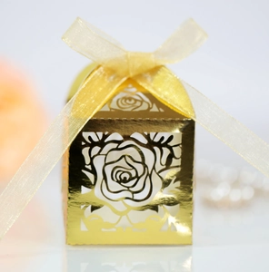 Close-up of laser-cut rose hollow favor box with elegant gold ribbon and metallic finish