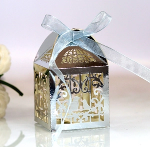 Detail of silver laser-cut love bird candy box with blue ribbon for wedding gifts