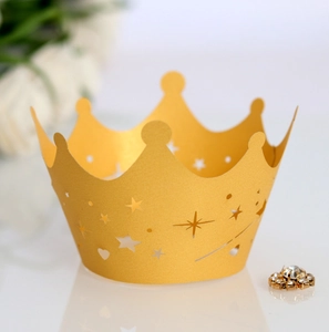 Close-up of golden crown laser-cut cupcake wrapper with star and heart hollow patterns