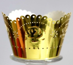 Close-up of golden laser-cut cupcake wrappers with elegant rose patterns and wavy edges