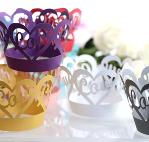 Close-up of laser-cut heart cupcake wrappers with Love text for wedding party decor
