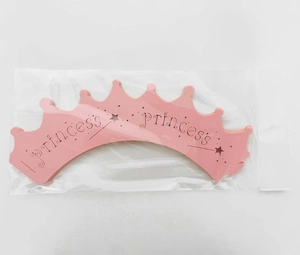 Pink laser-cut princess crown cupcake wrappers in retail packaging for party decor