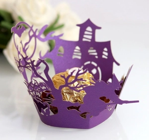 Detail of purple laser-cut Halloween cupcake wrapper with witch and bat motifs
