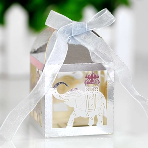Detail of silver laser-cut elephant favor box with a light blue satin ribbon bow