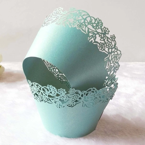 Close-up of laser-cut floral cupcake wrapper with light blue pearlescent finish