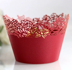 Macro shot of red laser-cut cupcake wrapper with rose pattern and pearlescent finish