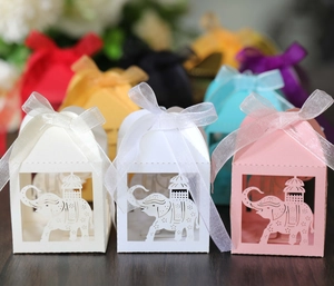Macro detail of laser-cut elephant favor boxes with silk ribbons for wedding and parties