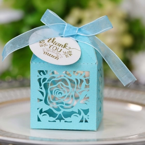 Detail of light blue laser-cut rose gift box with sheer ribbon and thank you tag