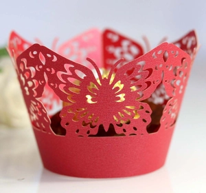 Laser cut red paper cupcake wrappers with hollow butterfly design and golden interior filler