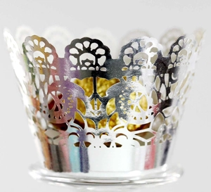 Macro detail of silver laser-cut cupcake wrappers with mirror finish lace floral pattern