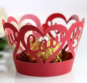 Close-up of red laser-cut cupcake wrapper with Love heart patterns and scalloped edge
