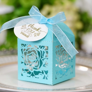 Light blue laser-cut rose gift box with thank you tag and ribbon on a porcelain plate