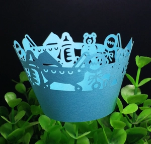 Detailed laser-cut baby blue cupcake wrapper with stroller and teddy bear motifs