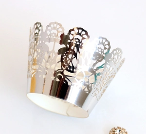 Close-up of silver laser-cut cupcake wrapper with intricate floral crown lace pattern