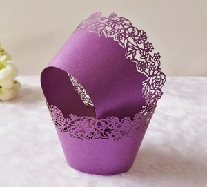 Detail of purple laser-cut cupcake wrappers with elegant floral pearlescent paper patterns