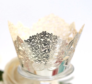 Macro view of champagne gold lace cupcake wrapper with intricate floral crown laser cut details