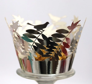 Vue macro de caissettes à cupcake argentées découpées au laser avec motifs d'oiseaux