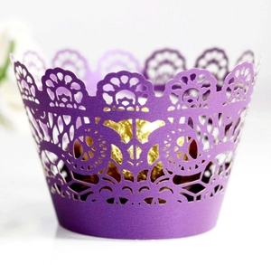 Macro shot of laser-cut purple cupcake wrapper with intricate mandala lace pattern detail