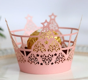 Détail macro d'un moule à cupcake rose découpé au laser avec motifs d'étoiles et de vignes