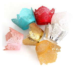 Intricate laser-cut lace cupcake wrappers in various vibrant metallic colors and floral designs