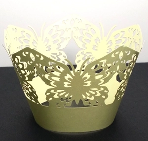 Close-up of laser-cut butterfly cupcake wrappers in elegant golden paper finish