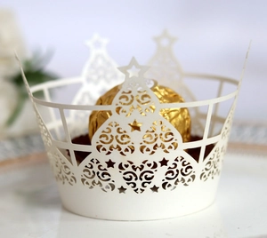 Vue macro de caissettes à cupcakes blanches découpées au laser avec motifs couronne et étoiles