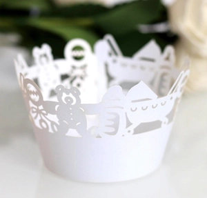 Close-up of laser-cut cupcake wrappers with bear and baby carriage hollow patterns