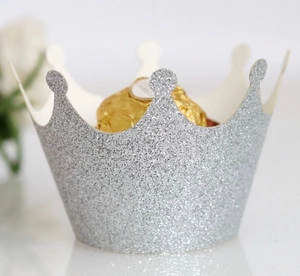Detail view of silver glitter crown cupcake wrapper with intricate scalloped cut edges