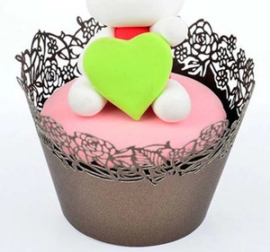 Detailed laser-cut cupcake wrappers featuring elegant rose floral patterns in metallic gold