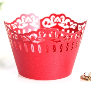Close-up of laser-cut red paper cupcake wrapper with elegant European hollow pattern