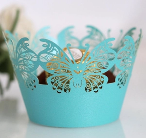 Close-up of light blue laser-cut cupcake wrapper with intricate butterfly pattern