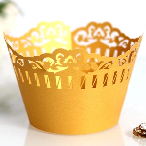 Macro shot of elegant golden laser-cut cupcake wrappers with intricate crown lace design