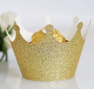 Close-up of a glittering gold crown cupcake wrapper holding a chocolate truffle for parties