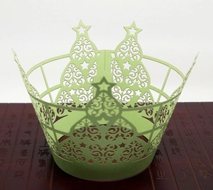 Détail de motifs de sapin de Noël découpés au laser sur des caissettes en papier vert clair