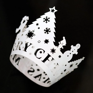 Detail of silver laser-cut Christmas tree muffin liners with Merry Christmas hollow design