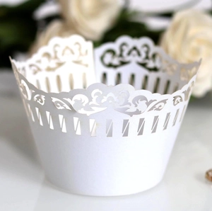 Close-up of white laser-cut filigree cupcake wrapper with elegant floral patterns