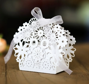 Close-up of laser-cut white hollow wedding gift box with elegant ribbon bow