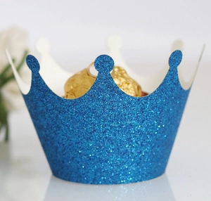 Close-up of royal blue glitter crown cupcake wrapper with golden foil chocolate