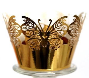 Detail shot of laser-cut gold butterfly cupcake wrapper with intricate metallic texture