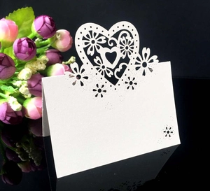 Dettaglio del segnaposto in carta avorio con cuore intagliato al laser e fiori