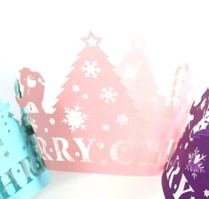 Close-up of laser-cut Christmas cupcake wrappers with tree and snowflake patterns
