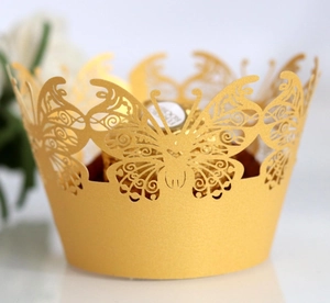 Laser cut butterfly cupcake wrappers in pearl gold for elegant party table decor