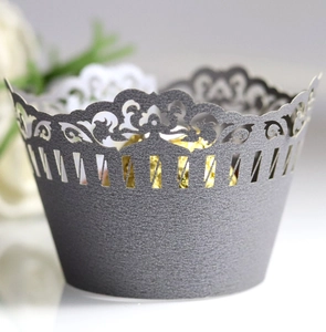 Intricate laser-cut silver cupcake wrapper with elegant crown patterns for wedding decor