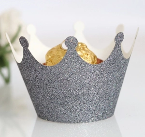 Detailed macro view of laser-cut crown cupcake wrapper with shiny silver glitter texture