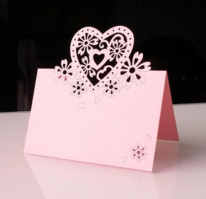 Dettaglio del segnaposto rosa tagliato al laser con motivi a cuore e fiori traforati