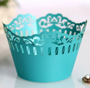 Close-up of laser-cut lace floral pattern on cyan wedding cupcake wrapper detail