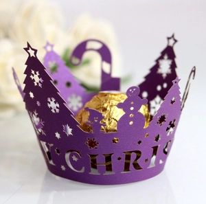 Detail of purple laser-cut cupcake wrapper with Merry Christmas snowman and tree motifs