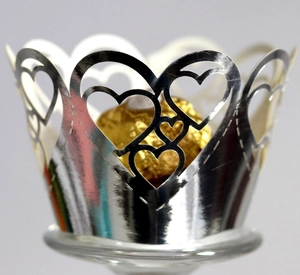 Silver laser-cut heart pattern cupcake wrappers with metallic finish for wedding decor