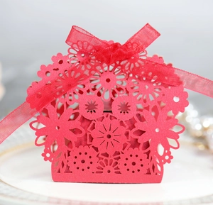 Macro view of red laser-cut candy box with floral patterns and a translucent ribbon bow
