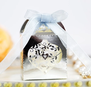 Silver hollow laser-cut wedding favor box with heart patterns and blue organza ribbon bow